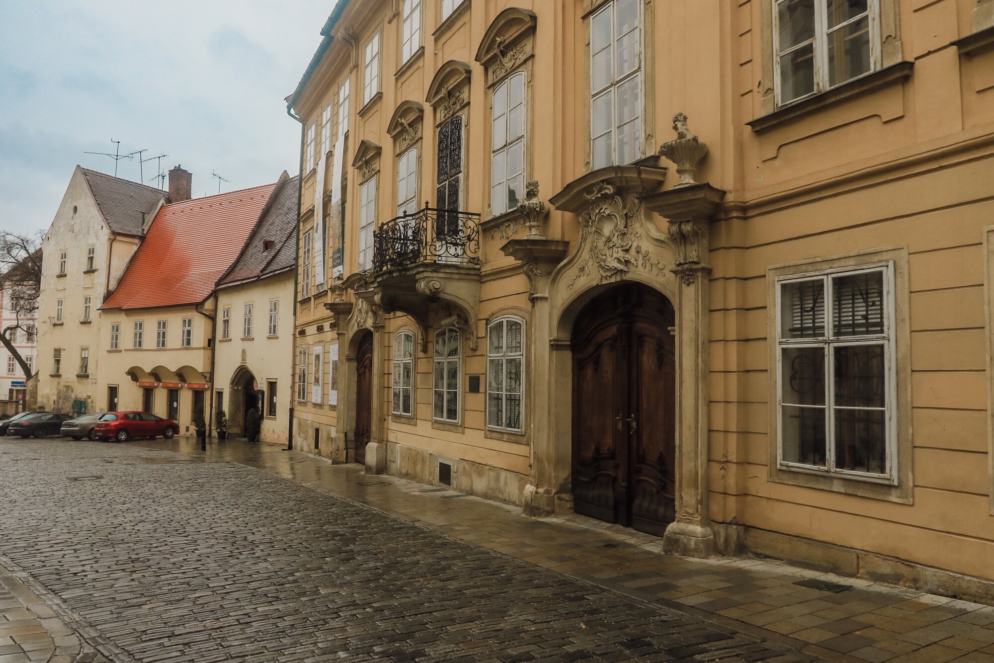 Exploring the charming streets of Bratislava on a rainy day with historic architecture and quaint buildings lining the cobblestone walkway