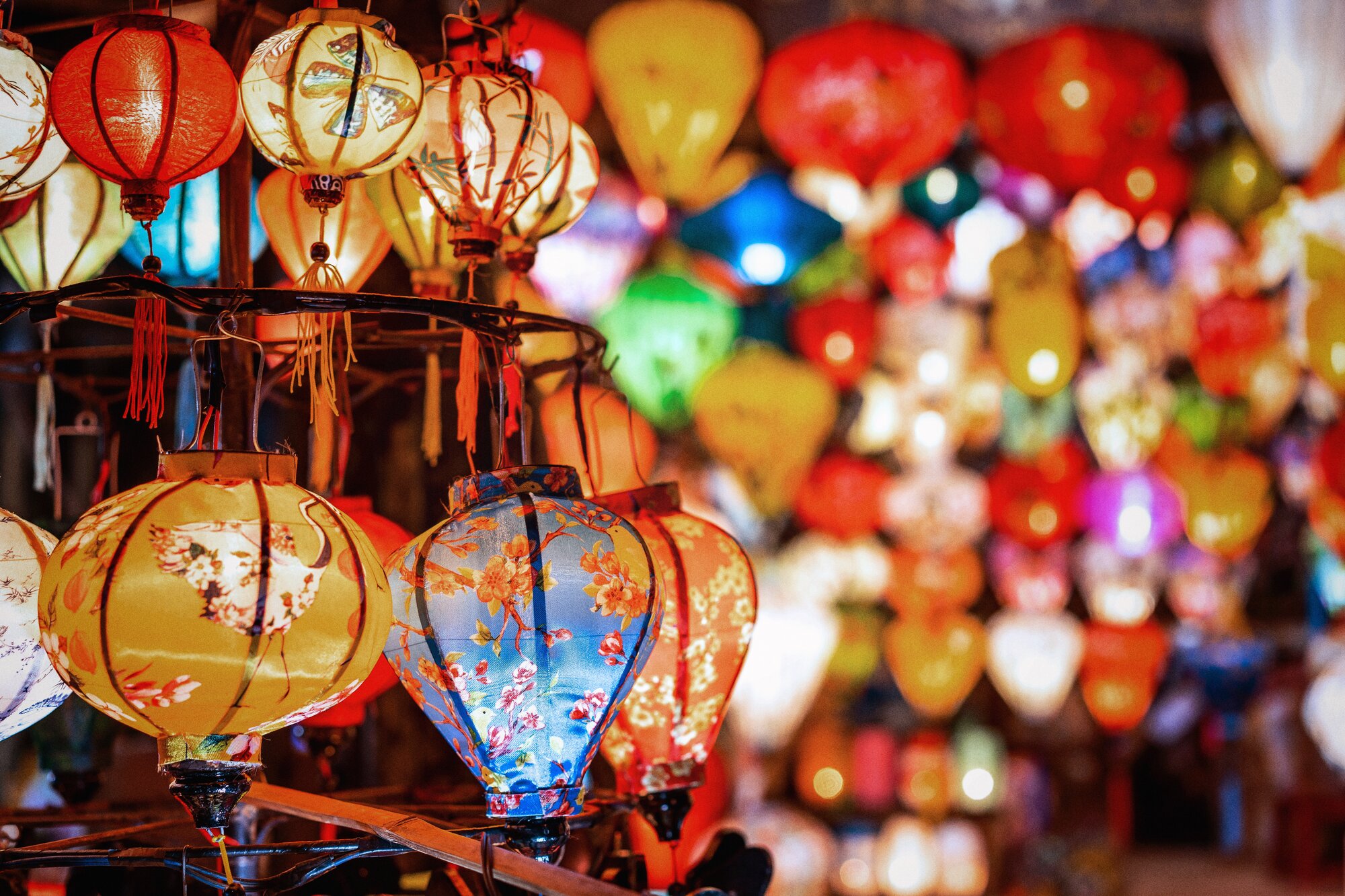 background with colorful Vietnamese hanging glowing silk lanterns in Vietnam in Hoi An city in night market in Asia