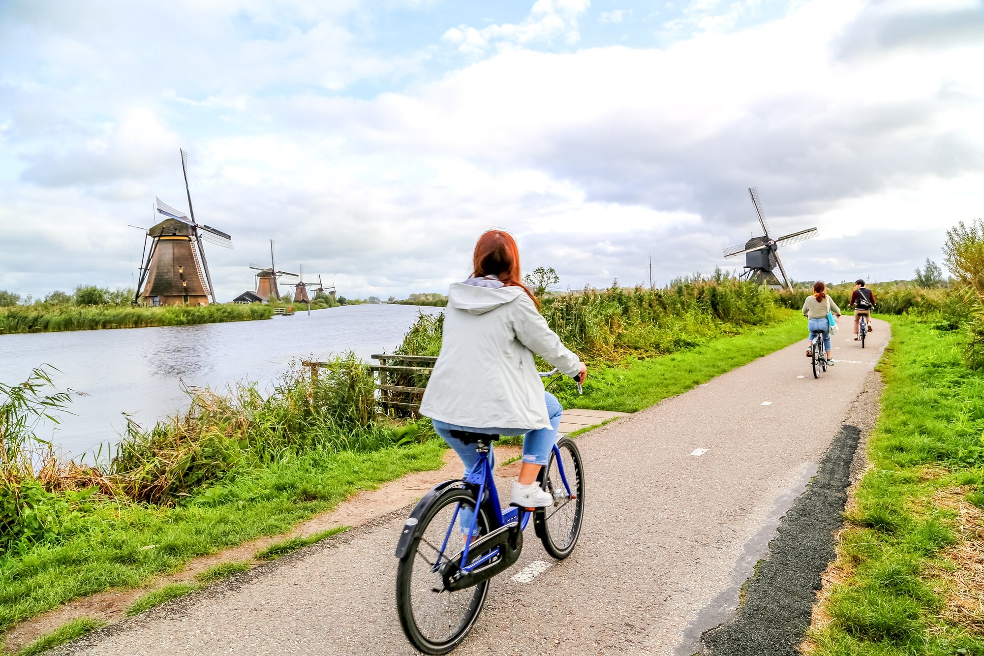 Windmills of Kinderdijk with people on bikes in front of it, Netherlands 