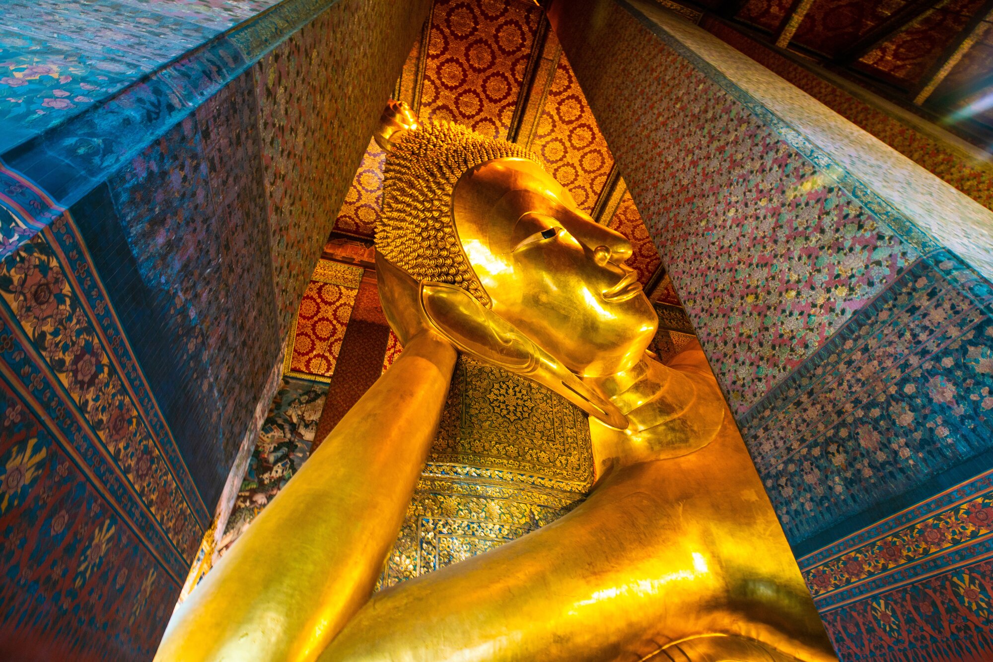 Golden big reclining buddhist statue in temple sightseeing in Bangkok thailand