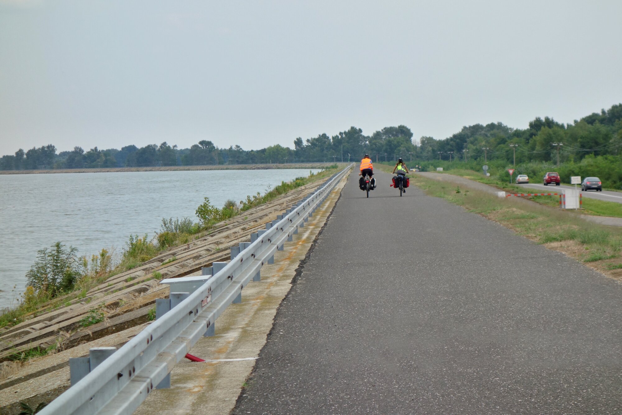 Cyclists ride along the cycle path along the Danube river, water dam Gabcikovo. Europe, Slovakia, the city of Bratislava. Cycling concept, cyclist rides a bicycle.