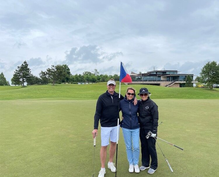 Jill posing for a photo with her family at the golf course
