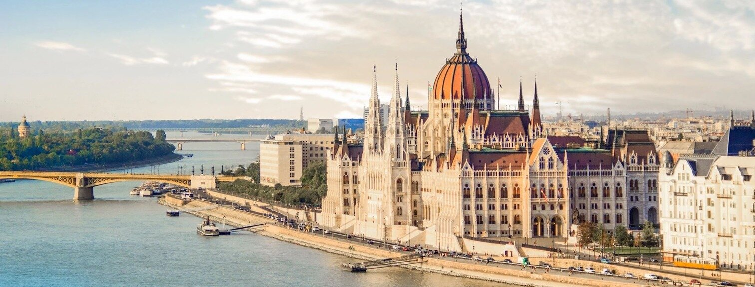 The Hungarian Parliament Building in Budapest, Hungary along the Danube river with a bridge nearby