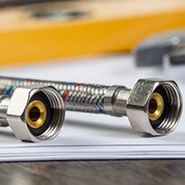 A couple of supply lines and fittings laying on a surface.