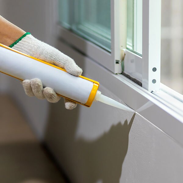 Applying caulking to a windowsill. 