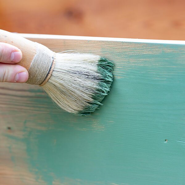 Chalk paint being applied to a wooden surface.