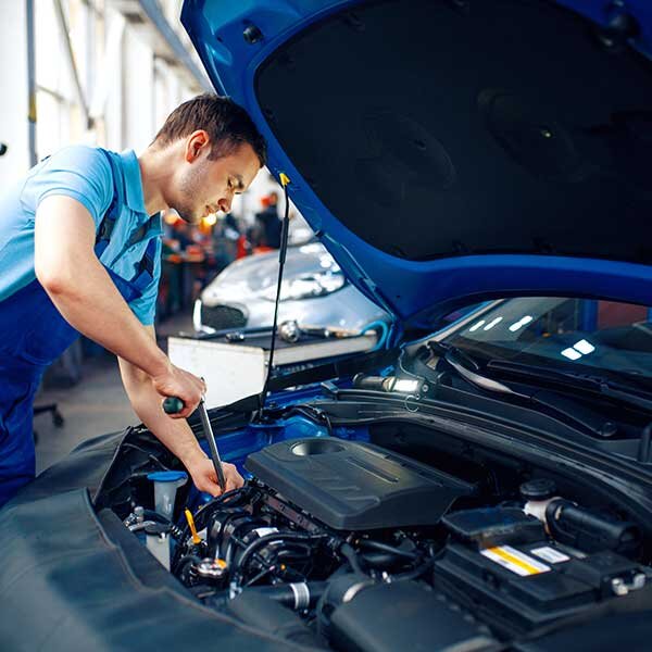 A mechanic repairing a vehicle in the shop.
