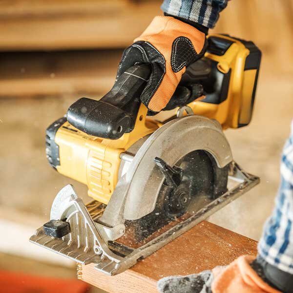 A cordless power saw being used to cut lumber.