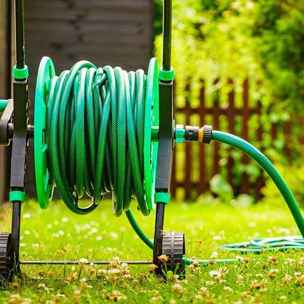 A hose on a reel in a backyard.