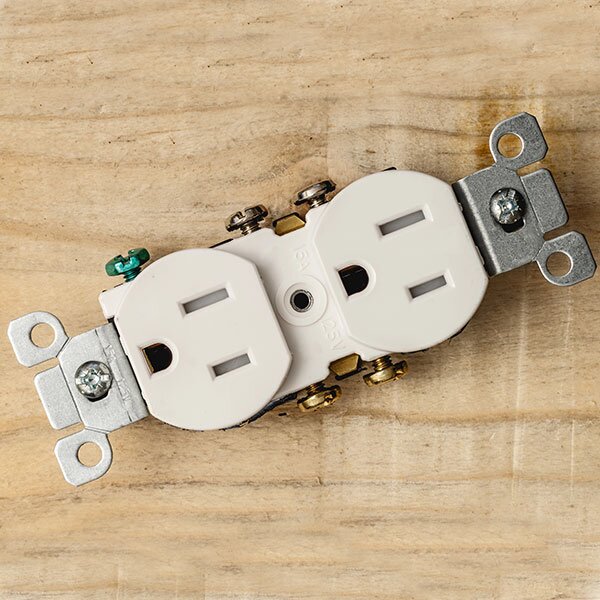 An outlet laying on a wooden surface.