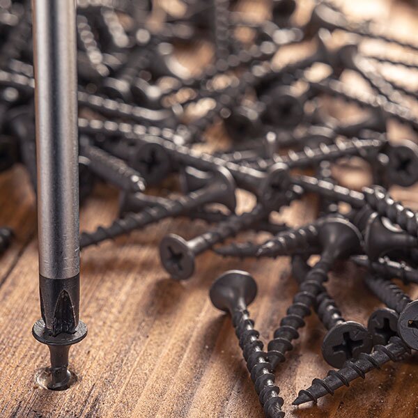 A screw being screwed in with a screwdriver.