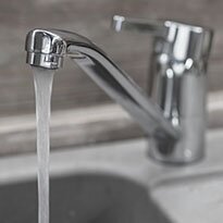 A basic sink faucet, open dispensing water.