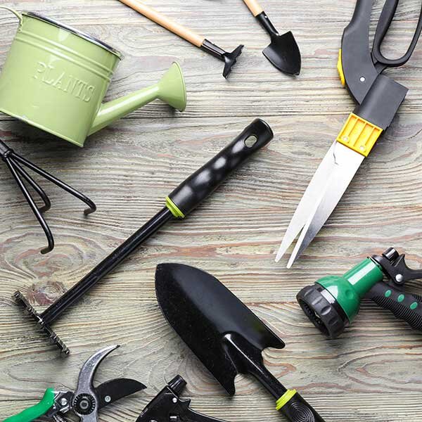 Garden tools on a grey wooden surface.