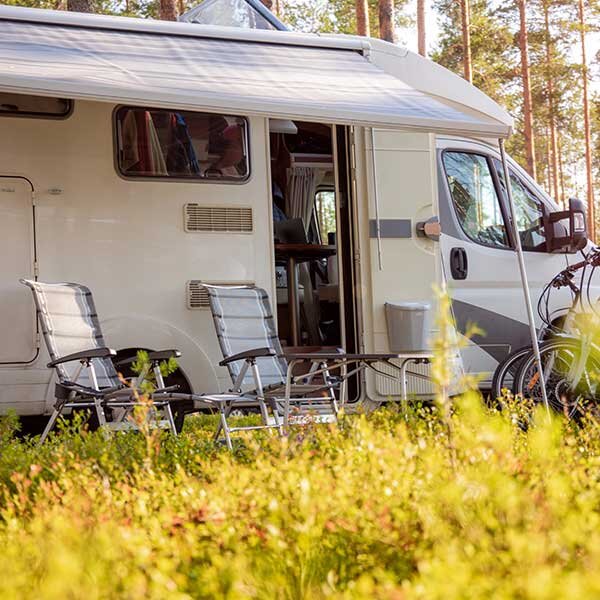 A RV parked, as the sun goes down.