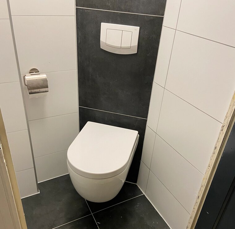 Voorbeeld waarbij het toilet in de hoek geplaatst wordt. Samen met een compact inbouwreservoir van Tece