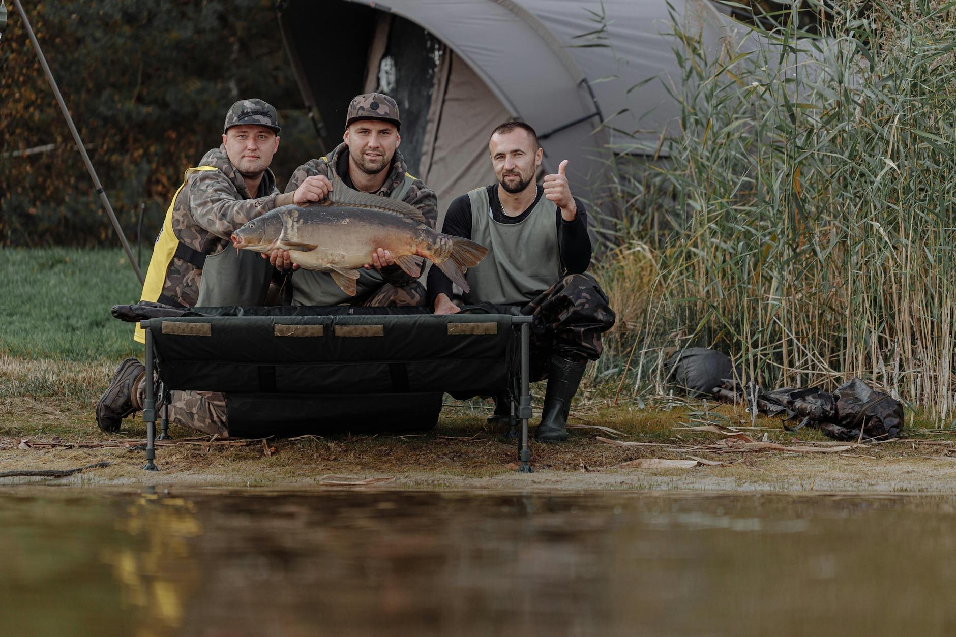 group of men posing with a big catch by the shore