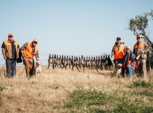 Group of sportsmen with a line pf harvested pheasants.
