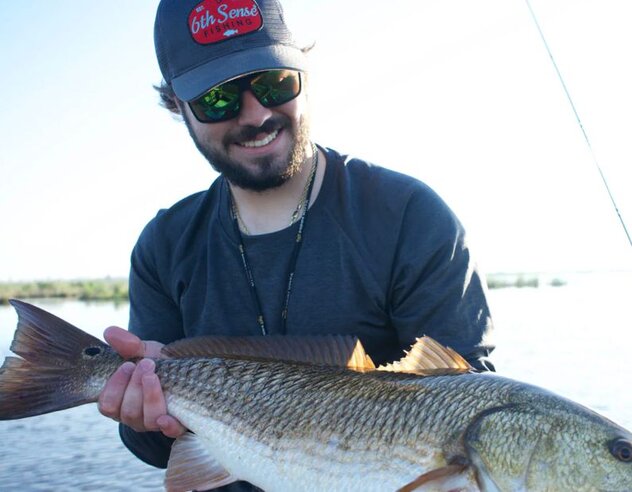 Capt. Brandt smiling with a Red Fish caught in the marshes of Houma, Louisiana