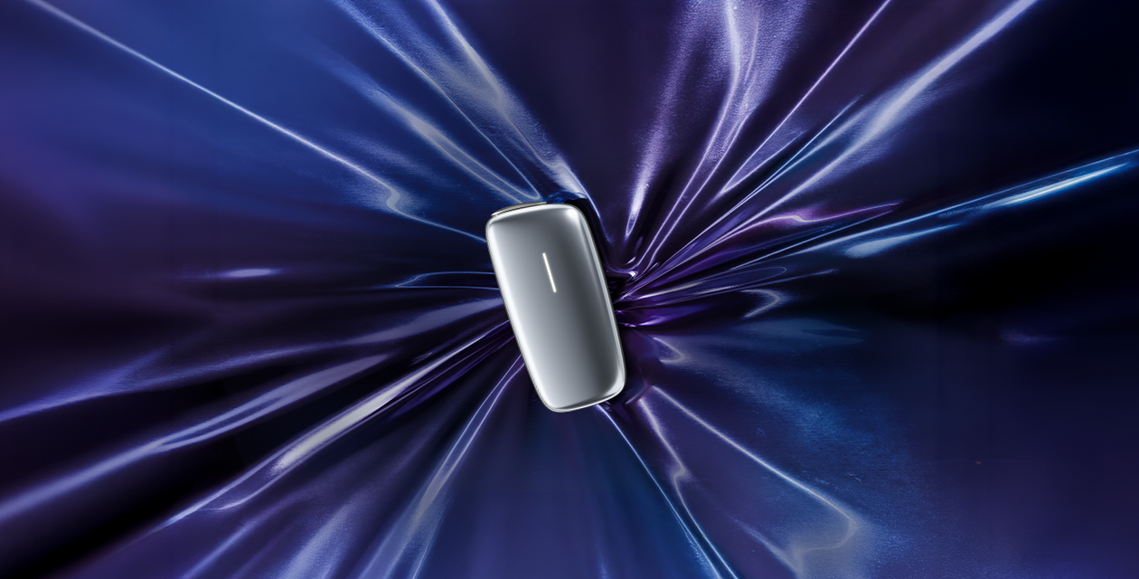 A silver-colored Ploom X Advanced placed in the center of a bright purple and blue fabric.