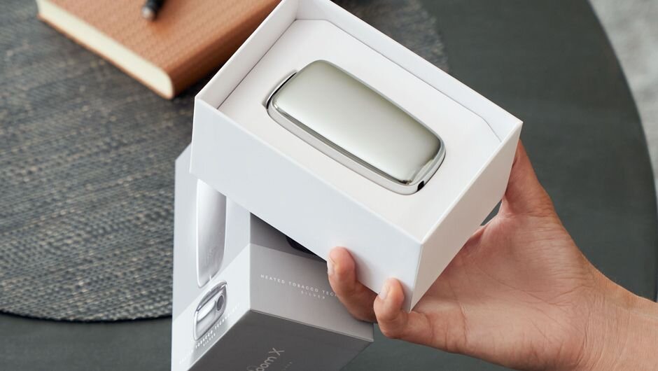 Ploom X Advanced cihazı ağ qutuda, masa üzərində açılmış Başlanğıc Paket təqdimatı