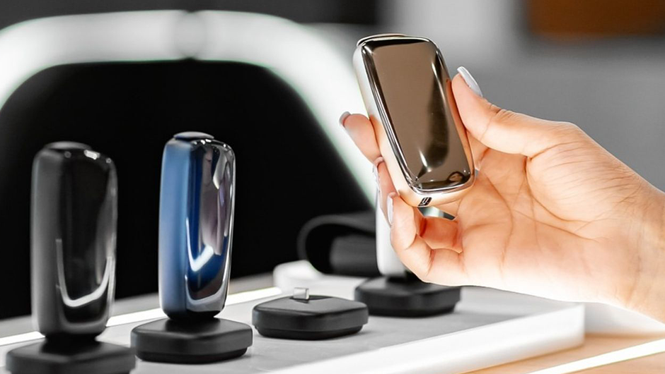 Vitrində müxtəlif rəngli Ploom X Advanced cihazları, parlaq metal korpuslu cihazları