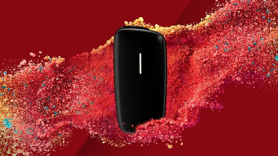 Ploom Ruby – new device visual presentation with red background and colorful powder effects.