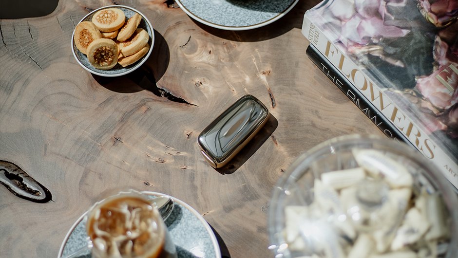 Cozy cafe moment with two iced coffees and a Ploom device on a wooden table