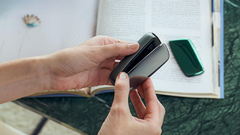 A person holding a Ploom front panel exchange process.