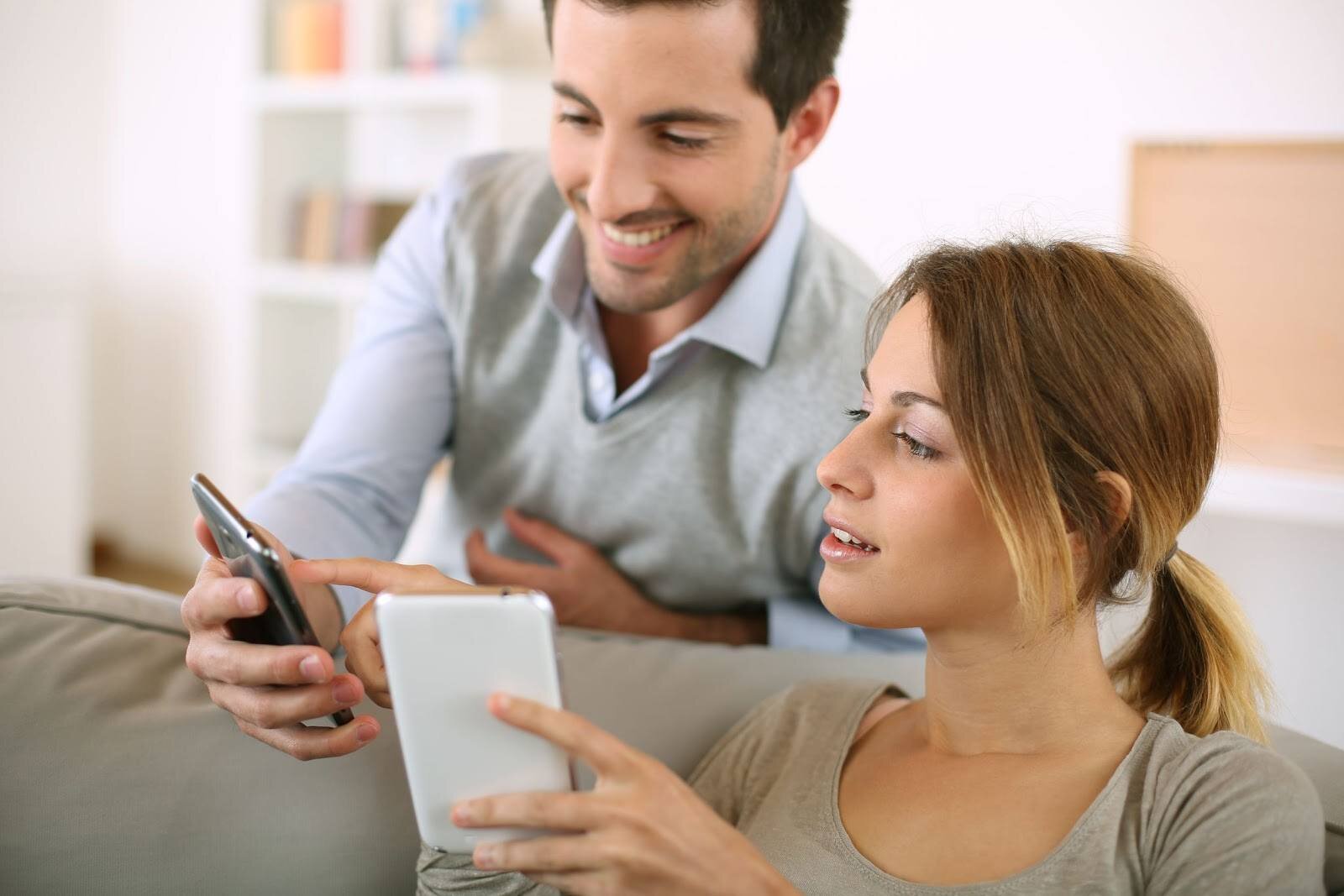 young couple using smartphone at home