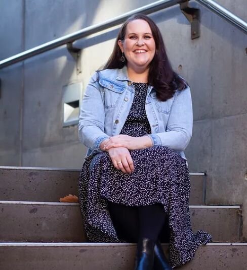 An image of Morwenna Collett sitting on some steps smiling