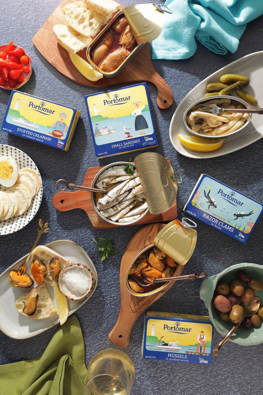 A spread of Portomar conservas &mdash; sardines, razor clams and mussels &mdash; with olives, lemon and bread
