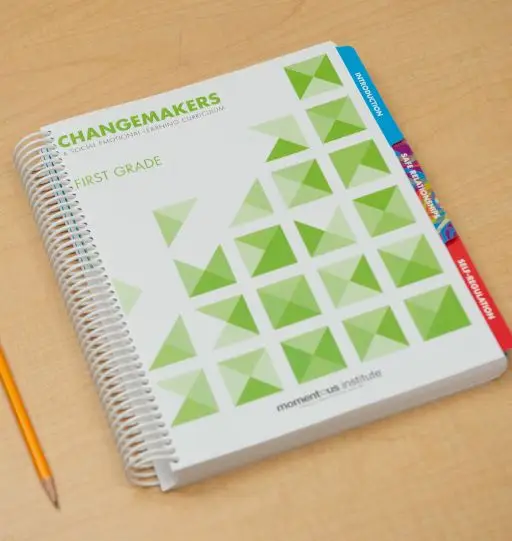 A Changemakers notebook on a wooden desk.