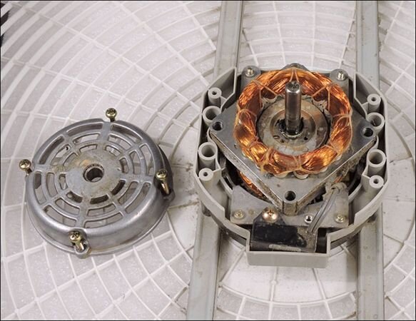 Partially disassembled electric motor showing copper magnet wire windings around the stator.