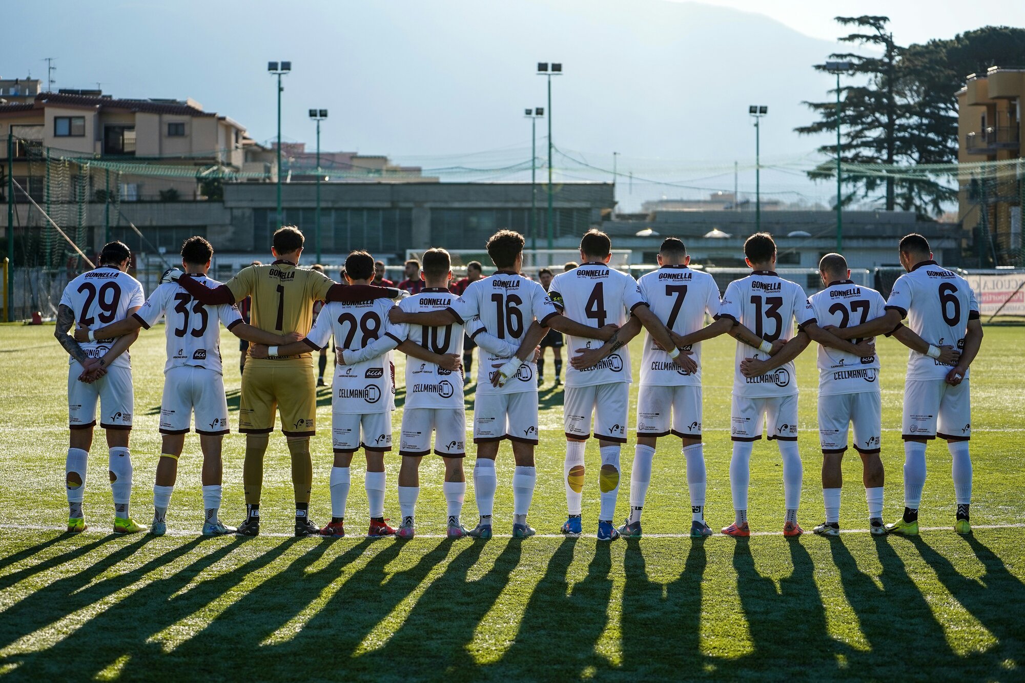 Jalkapallojoukkue valmistautumassa peliin peliasuissa