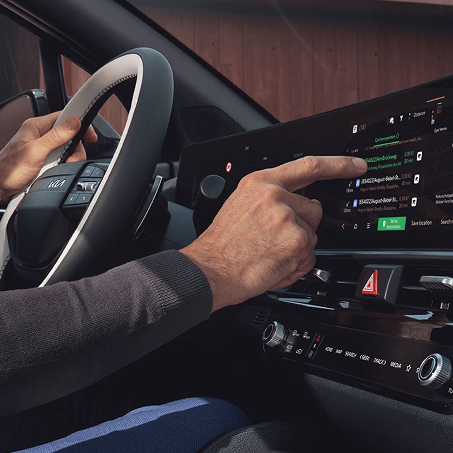 Eine Person bedient den Screen im neuen Kia Sportage