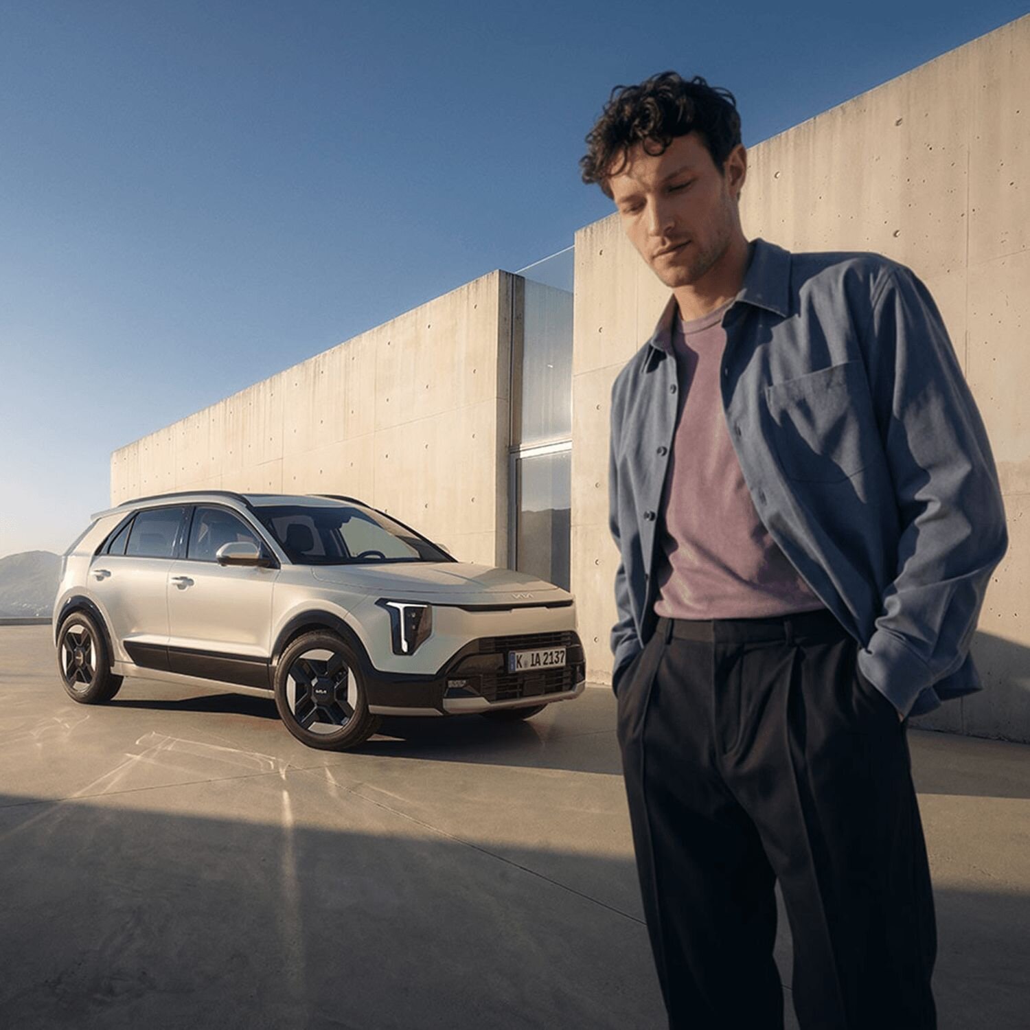 Ein Herr steht vor dem neuen Kia Niro