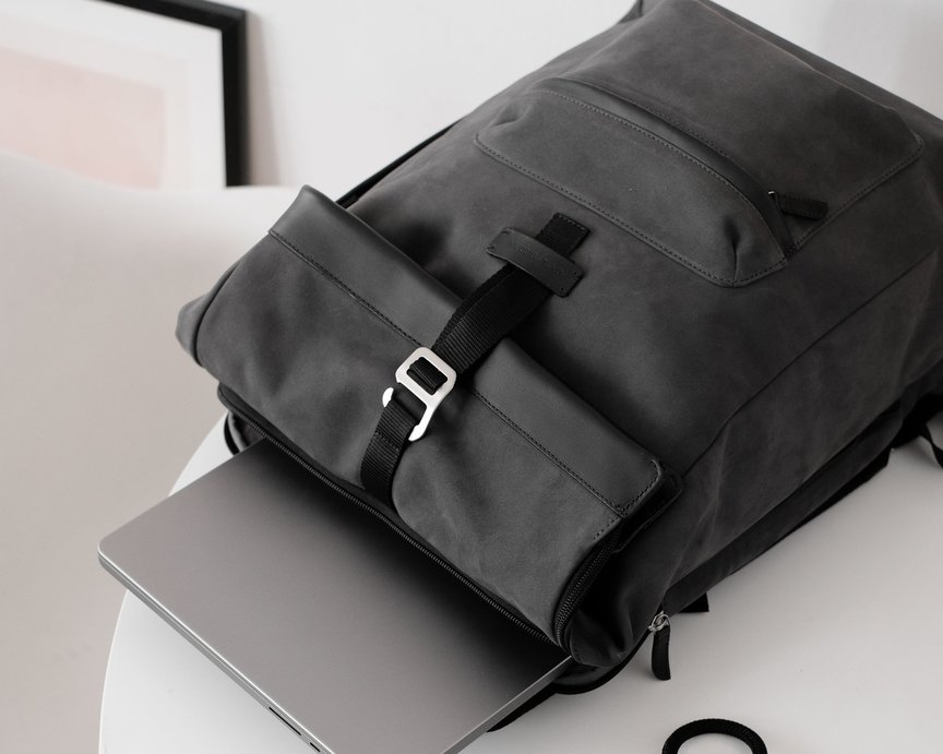 Grey nubuck leather backpack with laptop half inside laptop pocket