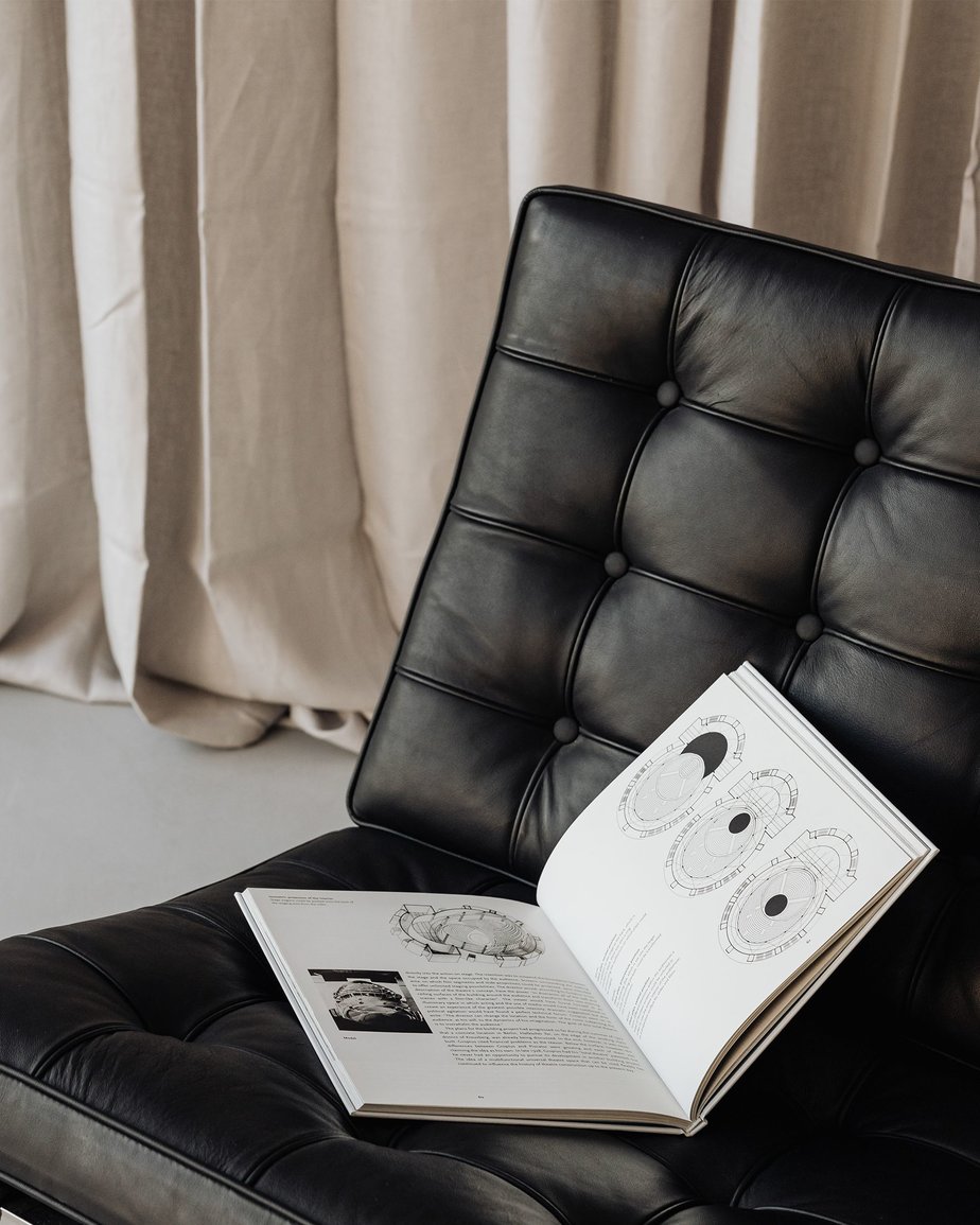 Open book rests on black PU leather sofa chair