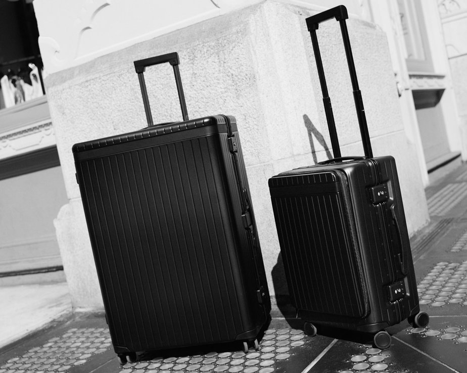 Elegant large black suitcase beside smaller cabin suitcase, shot on New York street