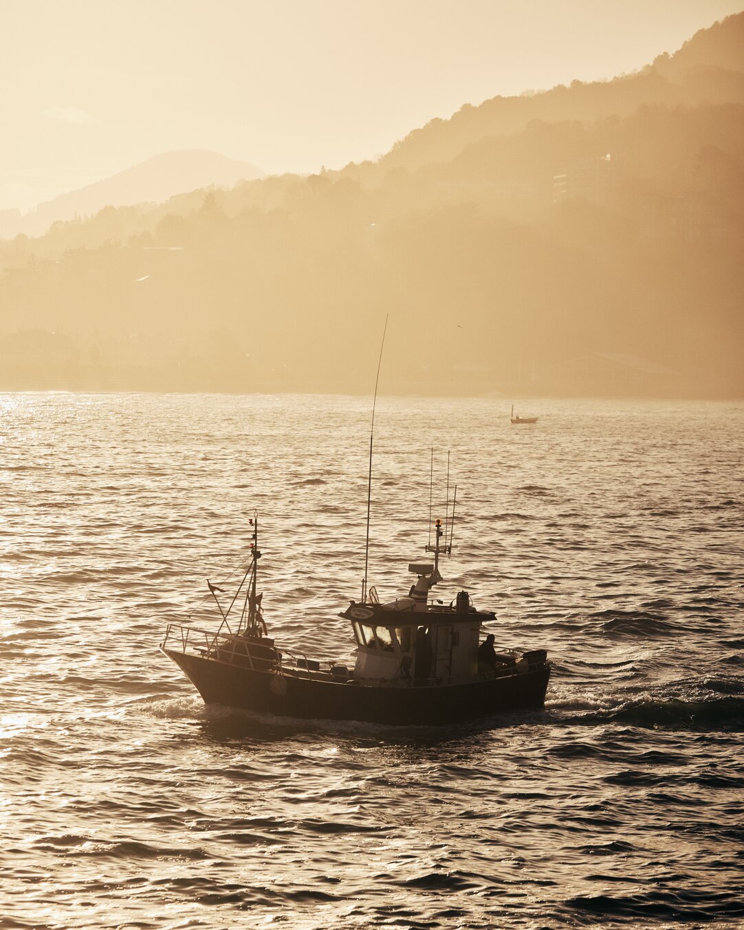 Fishing boat in the hazy sunlight off the San Sebastian coast