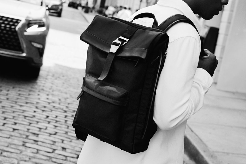 Man crosses New York street wearing white outfit and refined black nylon backpack