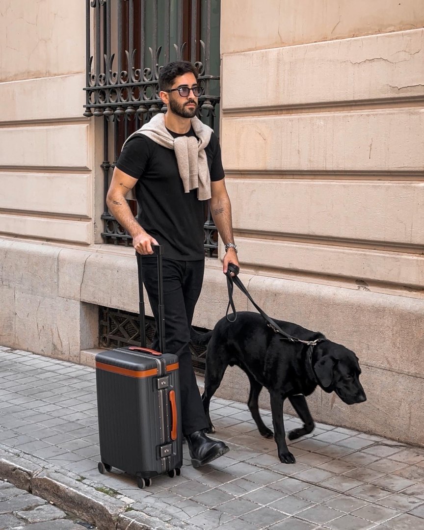 Bleisure traveller holding leather wallet wearing dressed down travel outfit