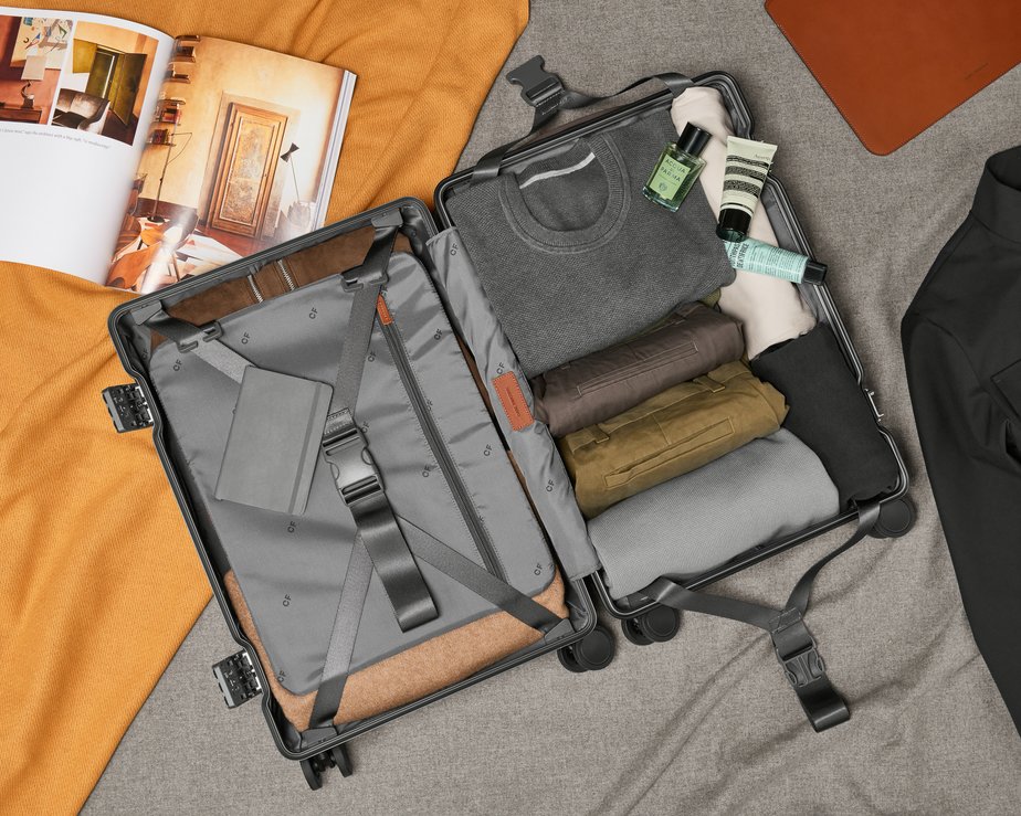 Carry-on luggage opened with clothes nearly folded inside