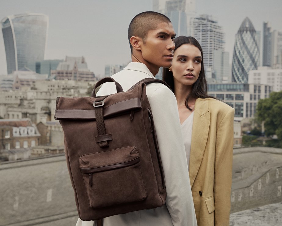 Man wearing stylish brown backpack next women in yellow top 