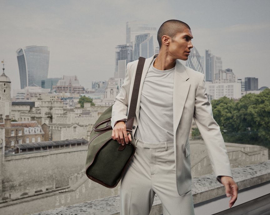 Stylish model holding green nubuck leather weekend bag 