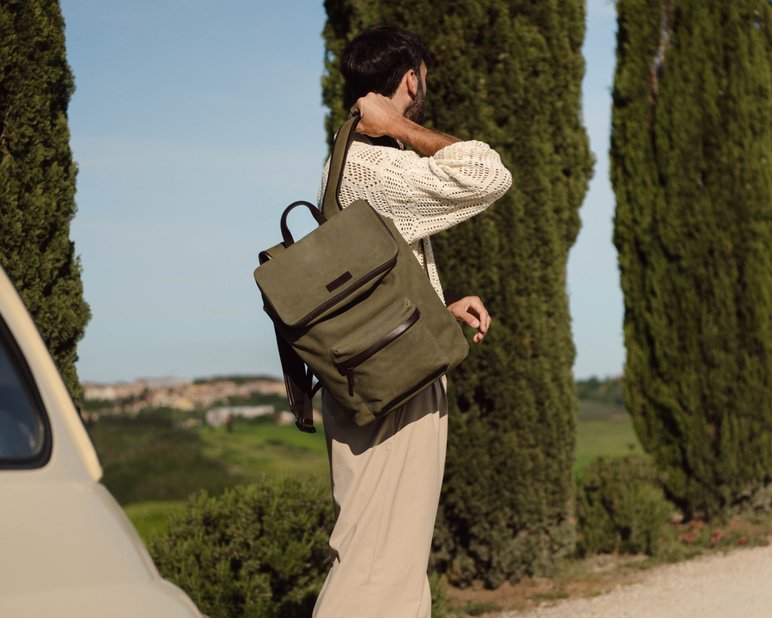 Man leaving the car carrying his backpack outside of Italy