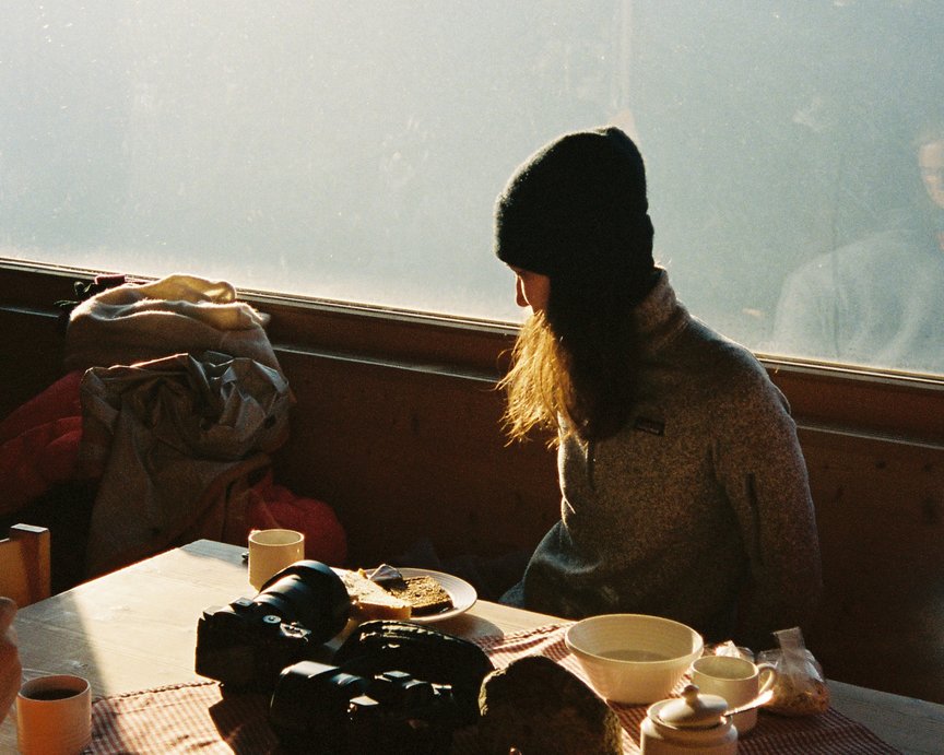 Woman relaxing while camping in a hut having breakfast and coffee