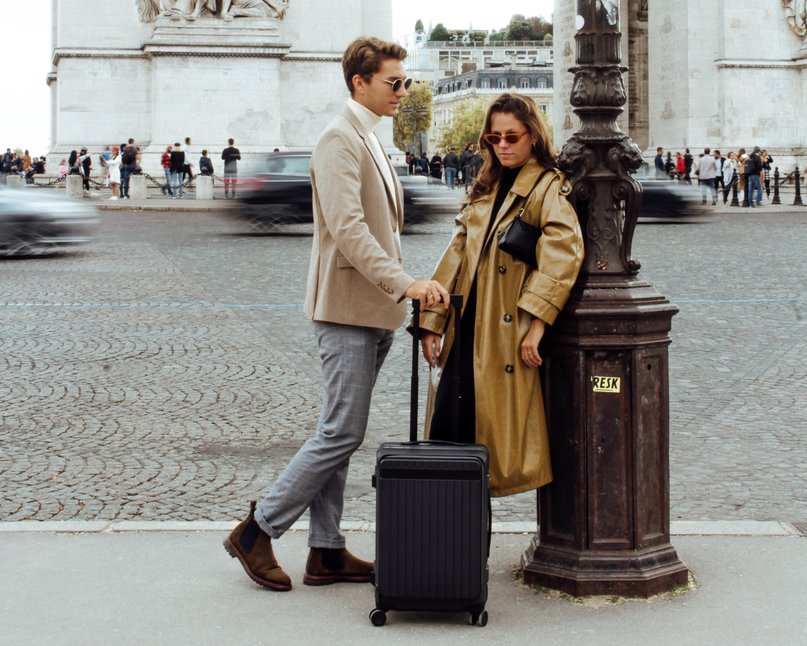 Bleisure travel couple standing with luggage in Paris