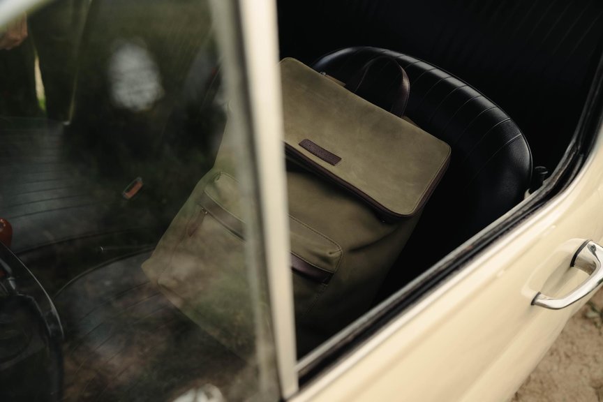 Green nubuck bag sat on passenger side seat in cream car