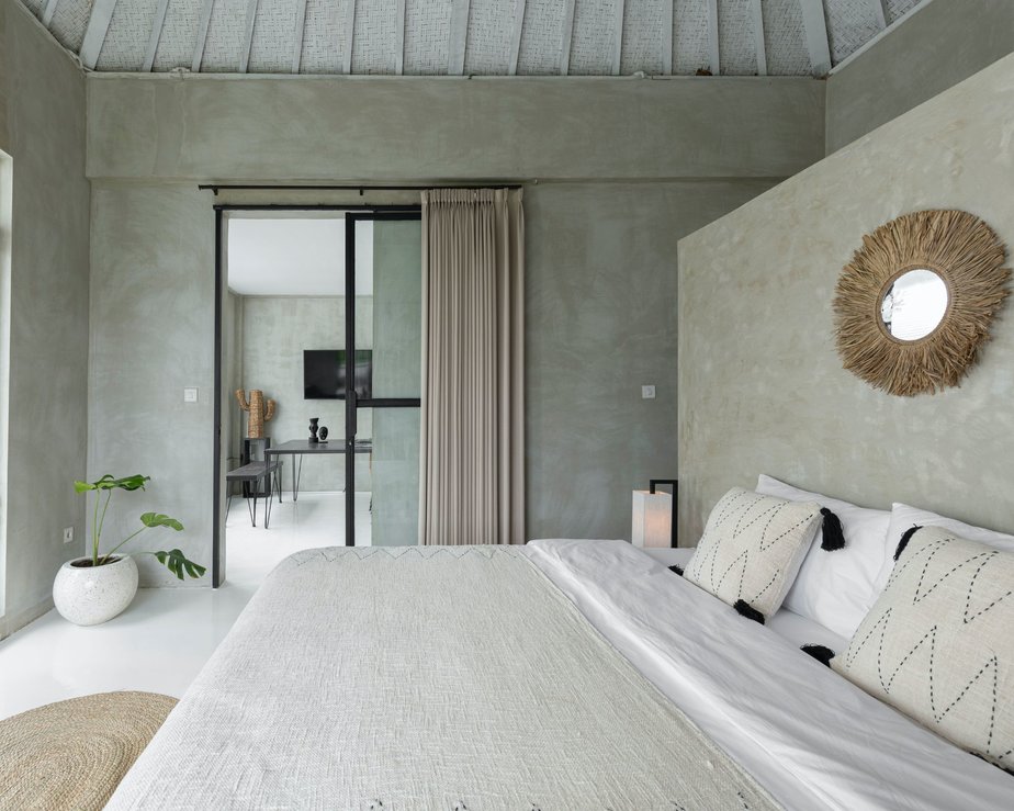 Minimalist bedroom with exposed walls and a large bed